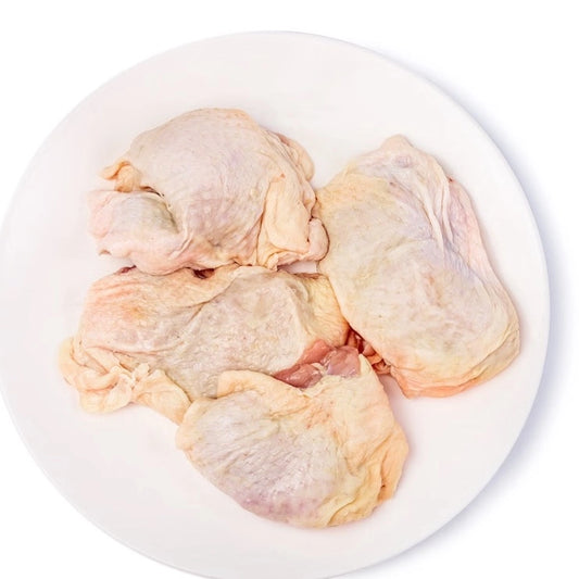 Raw chicken thighs on a white plate